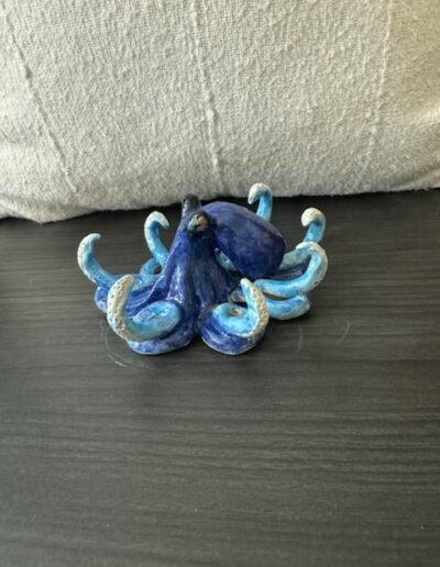 a blue octopus figurine on a black surface
