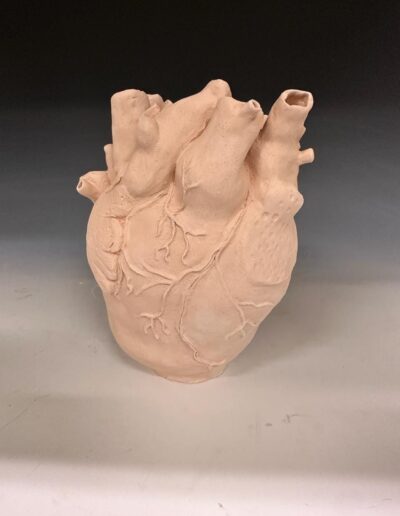 a clay snowman sculpture on a white surface