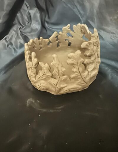 a bowl with leaves carved into it
